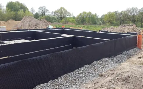 Fundament gotowy do zalania betonem. Czarna folia izolacja pozioma chroni przed wilgocią.