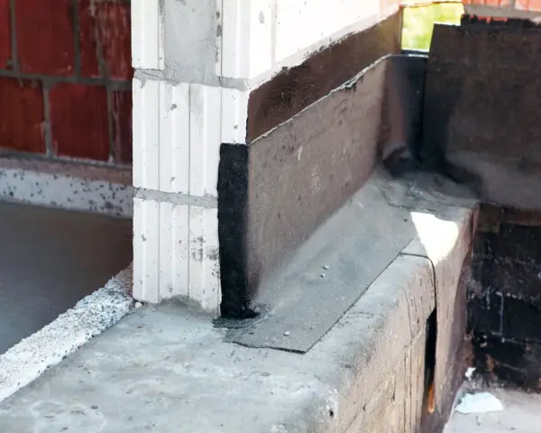 Papa do izolacji poziomej na styku ścian z bloczków i fundamentu. Zabezpieczenie przed wilgocią.